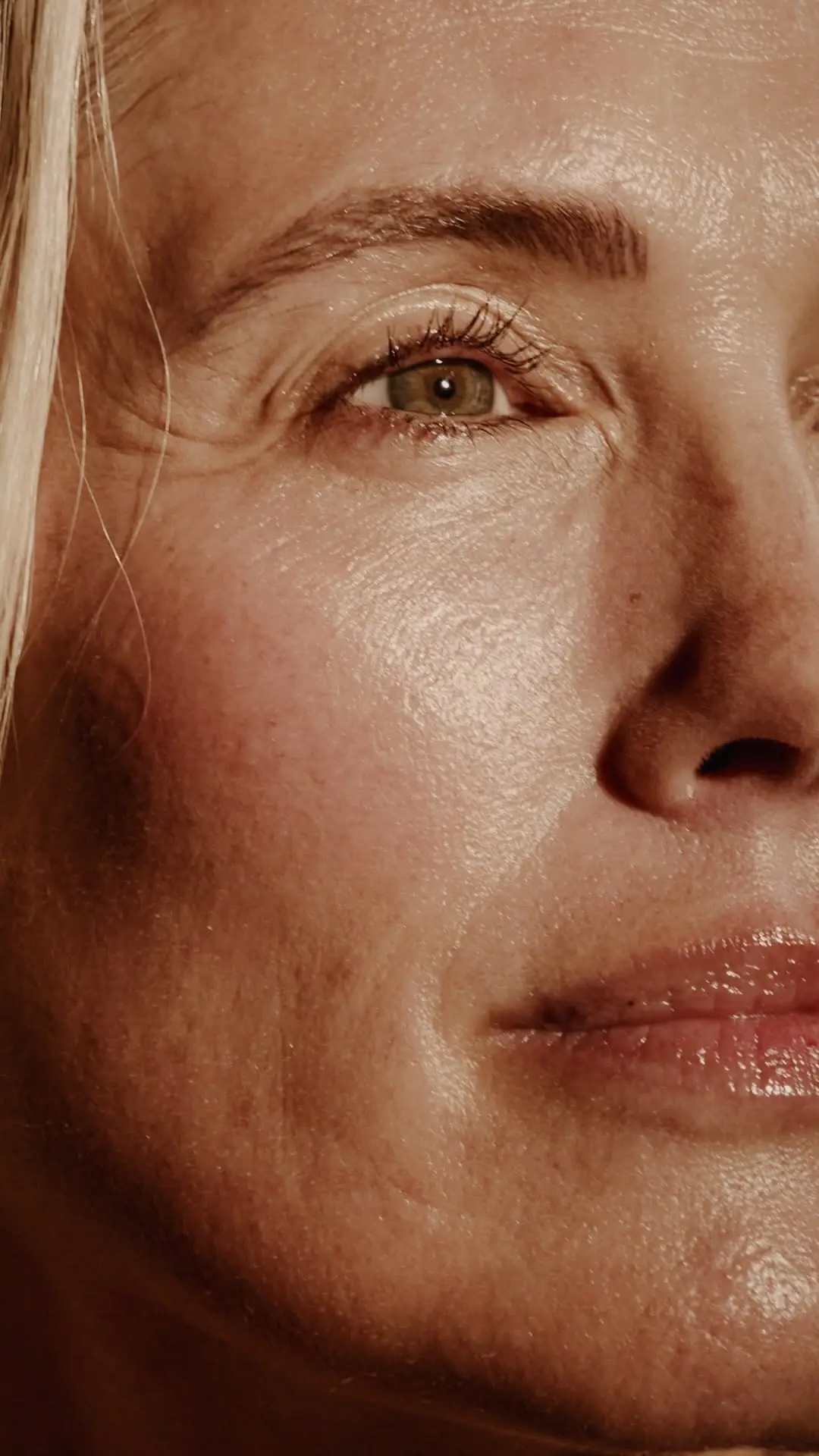 Close-up of hydrated facial skin around the eye showing natural freckles, pores and fine surface lines